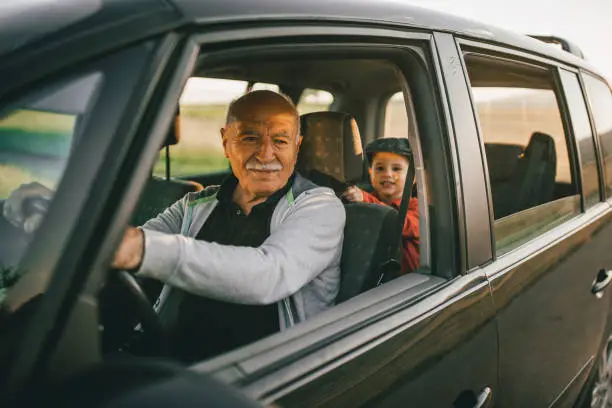 Grandfather and grandson having fun while traveling on the road trip