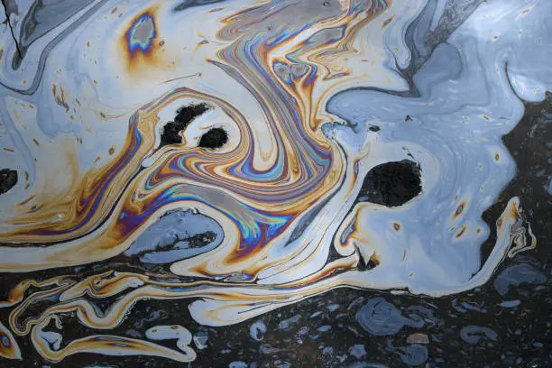 Photo of Tar water abstract fluid shapes iridescent colors