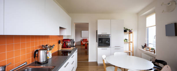 istock Kitchen with orange tiles and a modern table. Large window with a view 962898598