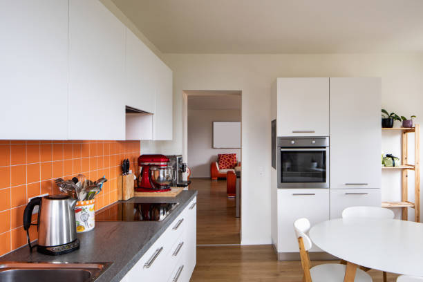 istock Kitchen with orange tiles and a modern table. Large window with a view 962898638