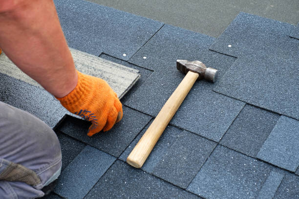 contractor hands installing bitumen roof shingles using hammer in nails. - fix up imagens e fotografias de stock