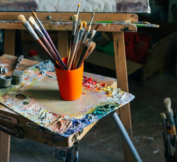 istock Brushes for drawing on an old wooden easel, stand on the floor 962903012
