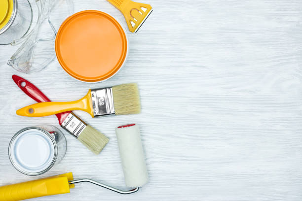 istock paintbrushes, rollers, knife, protective glasses and paint can on grey background 962903940