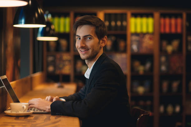 istock Portrait young smiling businessman typing and looking to camera 962910914