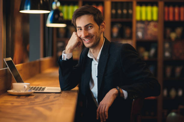 istock Portrait posing handsome young man in costume with laptop 962910944