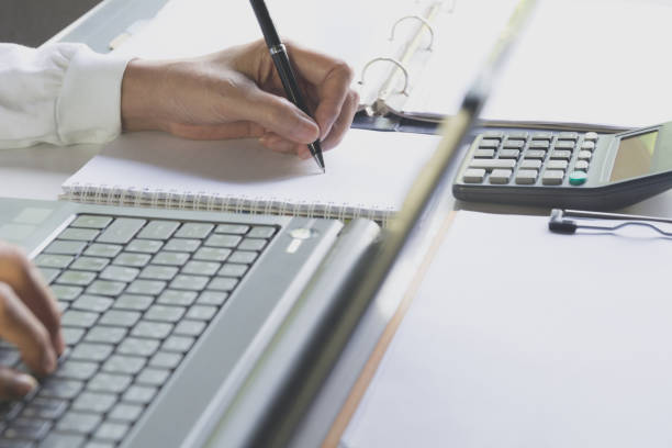 istock Person working and using a laptop for business and accounting concept. 962911312