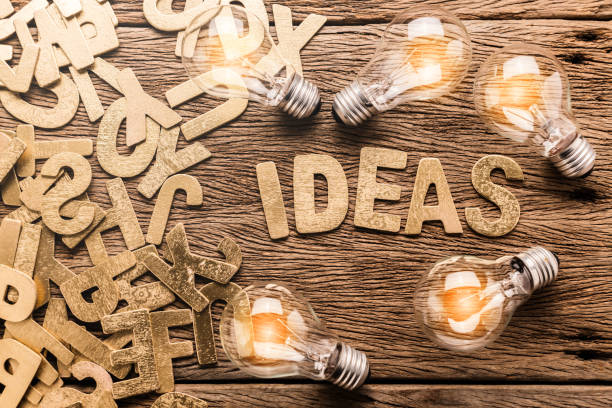 istock creativity ideas concept with light bulb on wooden texture background 962911654