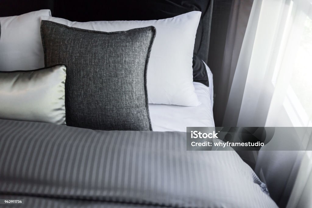 Bed maid-up with clean white pillows and bed sheets in beauty room. Close-up. Lens flair in sunlight. Pillow Stock Photo
