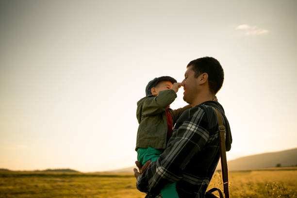 Father and son having fun on the field in the countryside