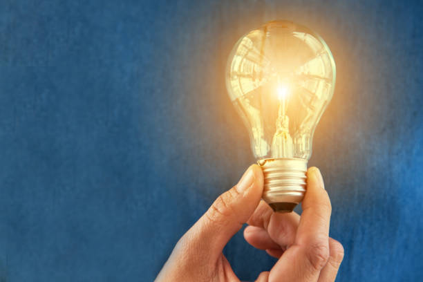 istock Light bulb in woman hand with orange light. Idea and Creative concept. Success and Thinking concept. Object and People theme. 962916622