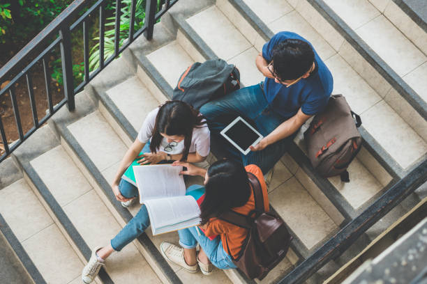 istock Group of Asian college student using tablet and mobile phone outside classroom. Happiness and Education learning concept. Back to school concept. Teen and people theme. Outdoors and Technology theme. 962916926