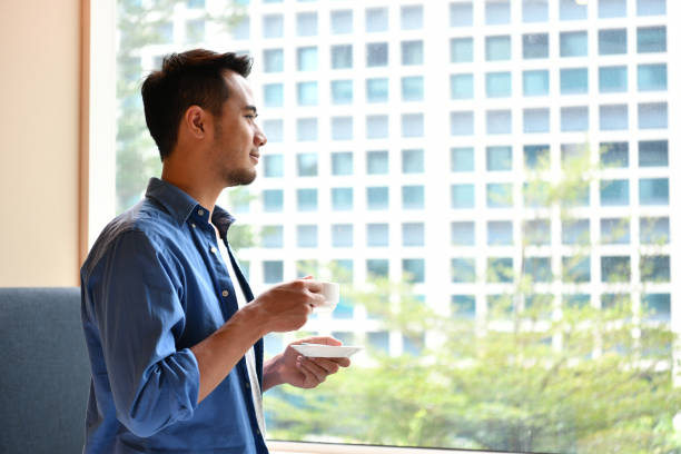 istock Young man drinking coffee in the room at home 962921272