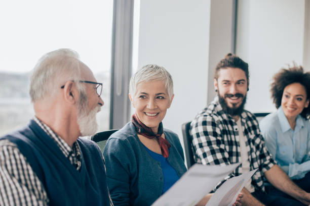 istock Businessman looking and smiling to coworkers 962921366