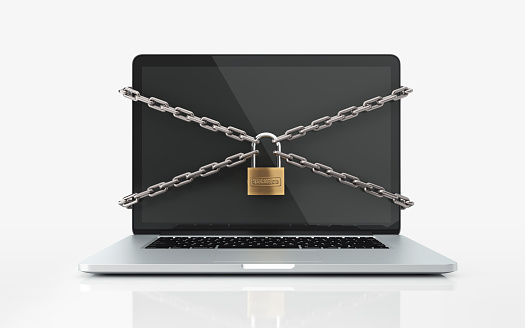 Laptop tied with chain and a padlock on white background. Computer and internet security concept. Horizontal composition with selective focus and copy space. Front view.