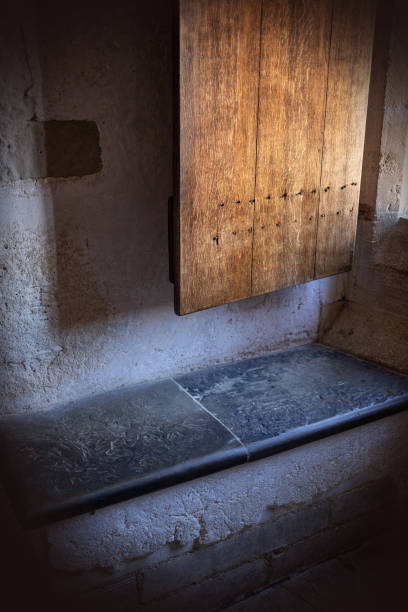 istock Old wooden shutter on a Tudor style window with a stone slab bench 962925006