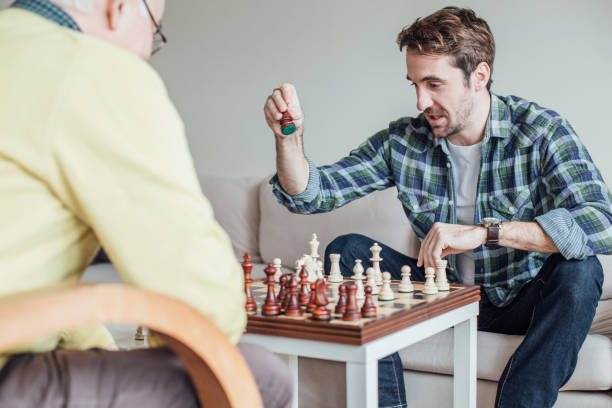 istock Young man holding chess piece in hand 962925032