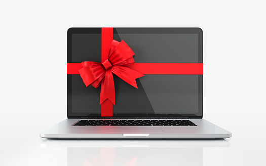 Laptop with red bow tie on white background. Horizontal composition with copy space.