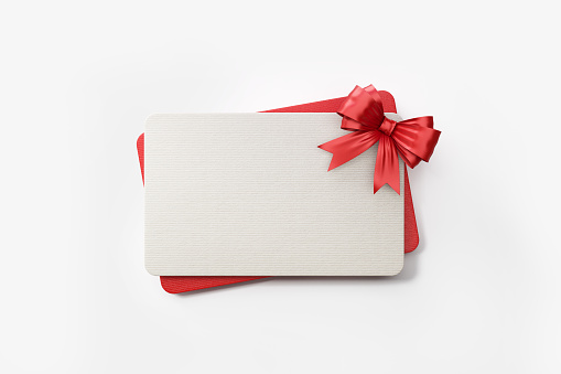 Red and white gift card with red colored bow tie on white background. Horizontal composition with clipping path and copy space.