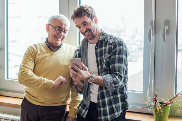 istock Father and son looking at smart phone and smiling 962929170