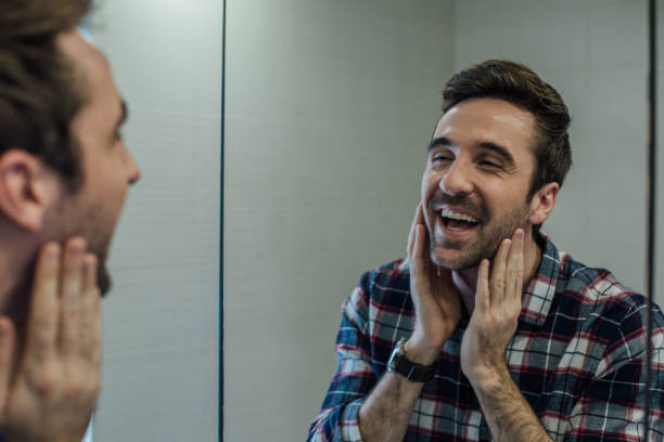 istock Satisfied man looking at his beard in the mirror reflection at bathroom 962929582
