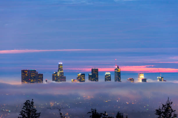 Stunning aerial view of Los Angeles, with a helicopter flying above the Griffith Observatory at sunset.