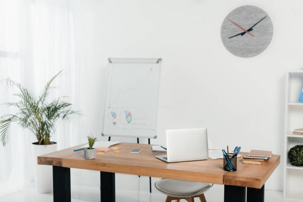 istock workplace with laptop and office supplies in office with white board and clock 962938462