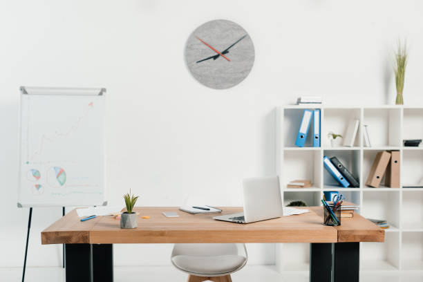 istock workplace with laptop and office supplies in office with white board and clock 962938500
