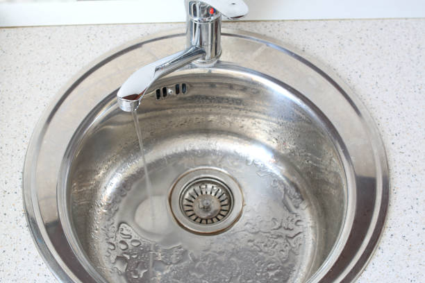 istock Chrome sink with running water from a faucet 962943904