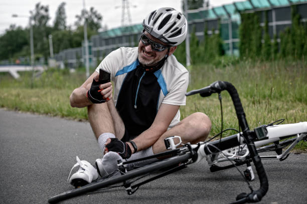 istock Injured biker holding his smartphone calling rescue team 962944428