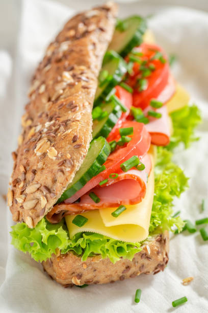 istock Delicious roll with cheese, ham and cucumber for breakfast 962944514