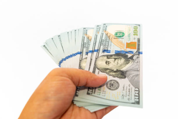 istock Close up of stack hundred new US dollar on hand 962947638