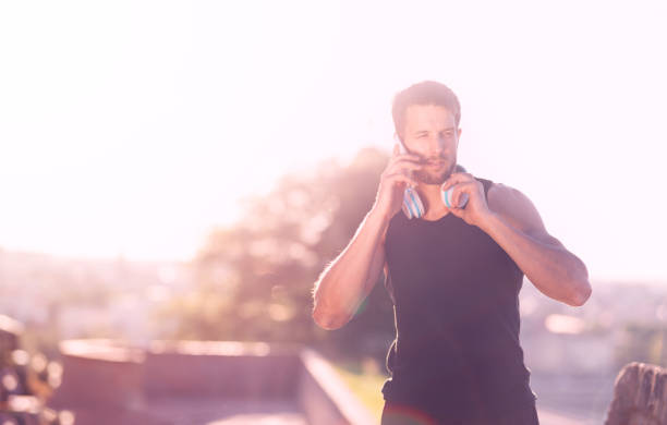 istock Young man in sportswear talking on phone while jogging 962951386