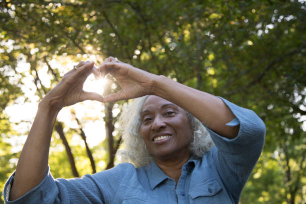 istock Senior Woman Outside Making 'Heart' 962952536