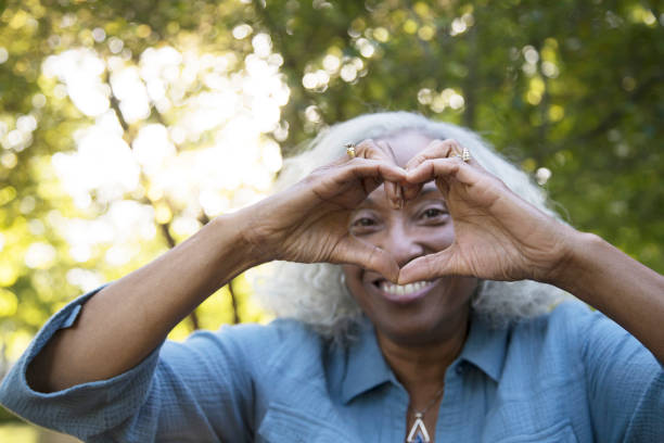 Senior Woman Outside Making 'Heart'