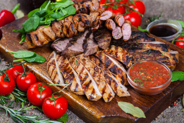 istock Mixed grilled meat platter. Assorted delicious grilled meat with vegetable. Mixed grilled meat with pepper sauce and vegetables. 962953140