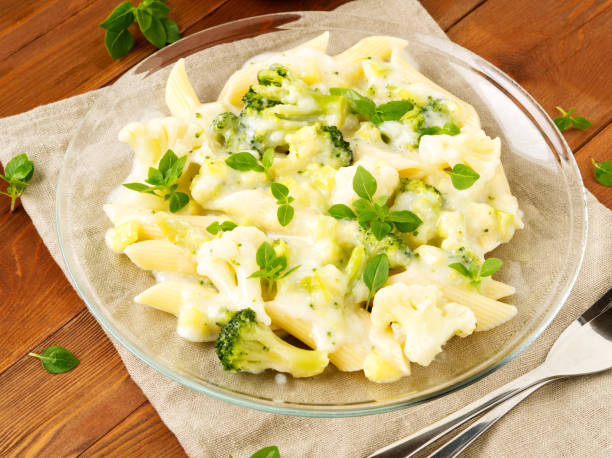 istock Broccoli spaghetti in glass plate on dark brown wooden table, side view, close up 962953920
