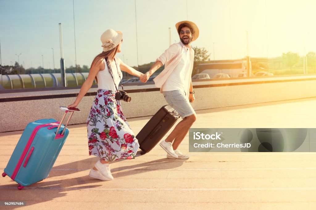 Happy couple arrived at the holiday destination Happy young couple landed at the airport, arrived at the destination of vacation Airport Stock Photo