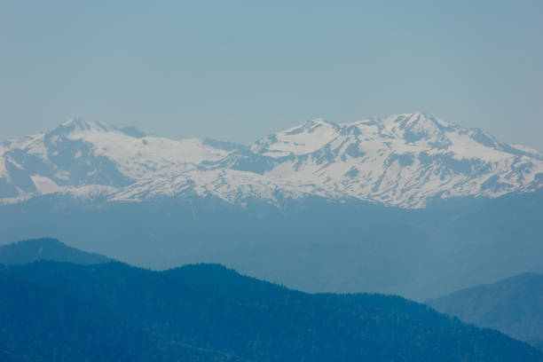 istock Mountains with peaks covered with snow, white clouds on blue sky, Caucasus 962959304