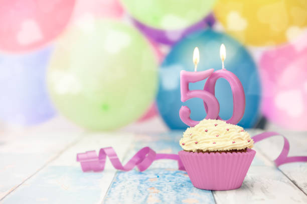 istock 50 anniversary celebration cupcake with candle 962962472
