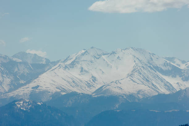 istock Mountains with peaks covered with snow, white clouds on blue sky, Caucasus 962963664