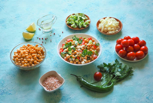 istock Salad with chickpeas. Set of sliced vegetables and chickpeas on a blue background with copy space. 962969362