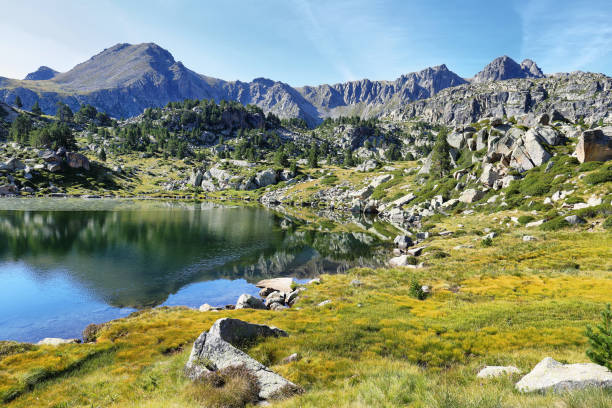 riflessione nel primo lago del circuito del lago pessons, andorra - granite travel foto e immagini stock