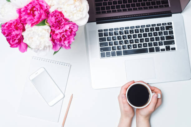 istock Workspace mobile phone laptop coffee hand peony 962974474