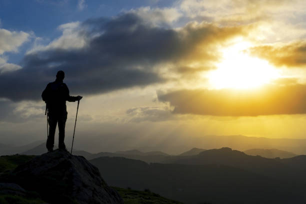 istock Hiker on the top of a mountain facing the sun. 962974676