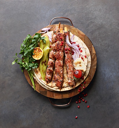 Kebab. Traditional middle eastern, arabic or mediterranean  meat kebab with vegetables and herbs. Overhead view, copy space