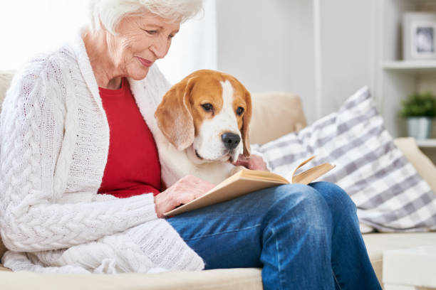 istock Loving Senior Woman Reading with Dog 962984430