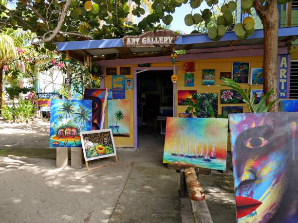PLACENCIA, BELIZE—JANUARY 2018: A wooden structure displaying an art gallery showcasing several beautiful works for sale by a local artist in Placencia, a small fishing near Harvest Caye in Belize.