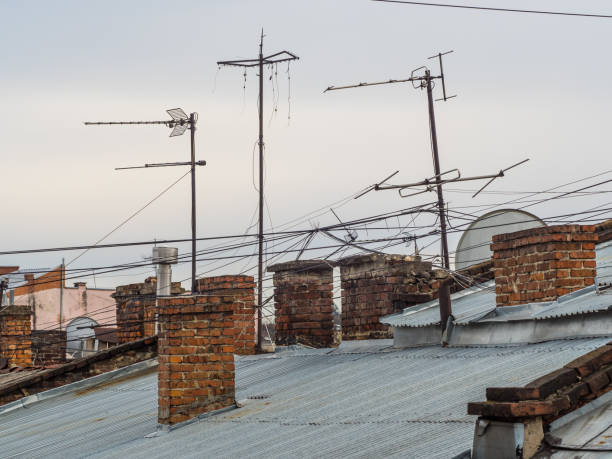 vieux toits dans une ville avec des antennes radio et de télévision dans une vue surélevée avec un ciel bleu dégagé. - romantic sky audio photos et images de collection