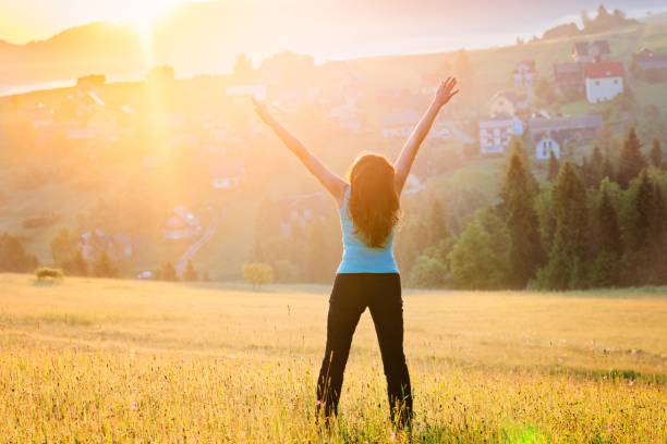 istock Woman with raised arms in mountains at sunrise 962995242
