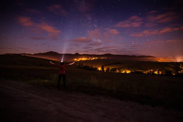 istock Young happy woman at starry night in mountains. 962995376